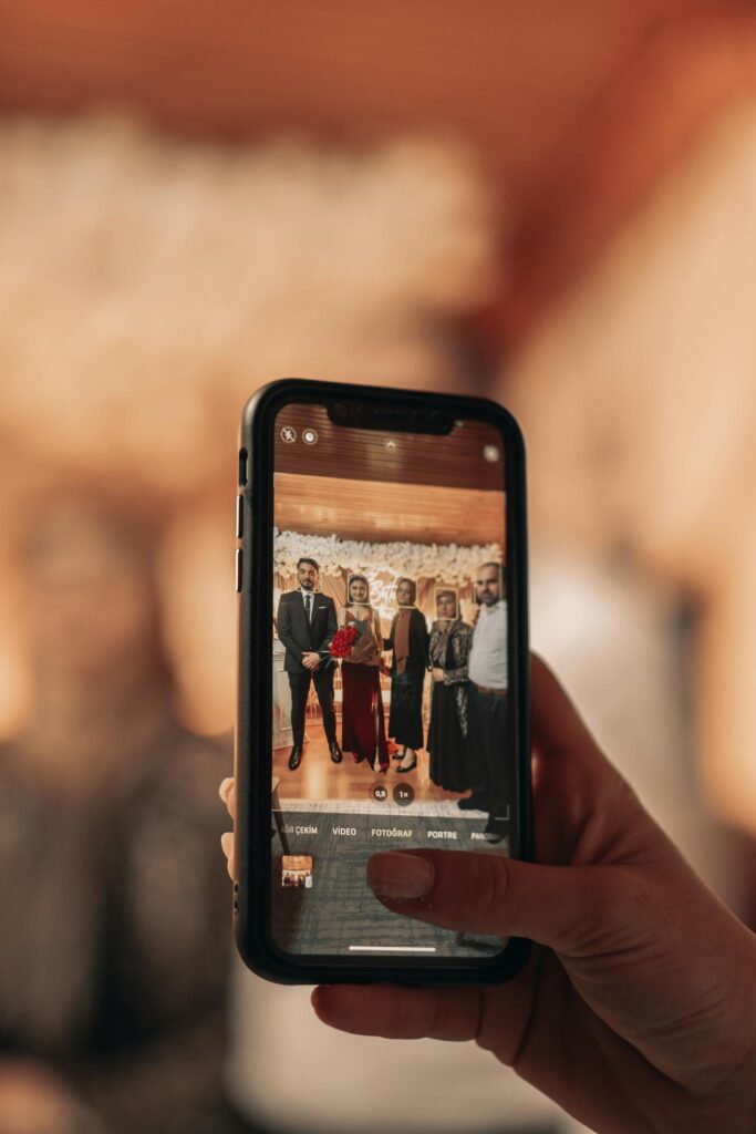 Woman Hand Holding Cellphone and Taking Picture of People
